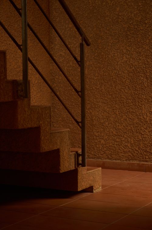 Free Moody indoor staircase captured in low light with textured walls and metal railing. Stock Photo