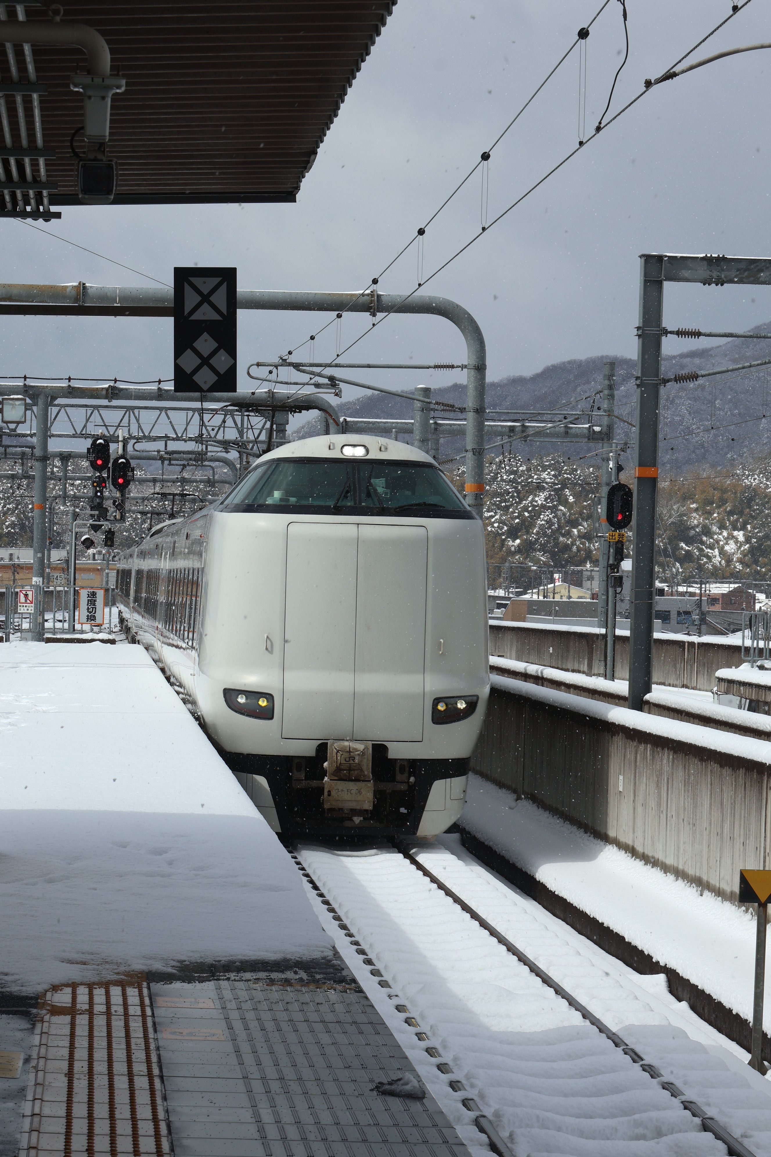 High-speed train arriving at snow-covered Fukuchiyama Station, Kyoto, Japan.