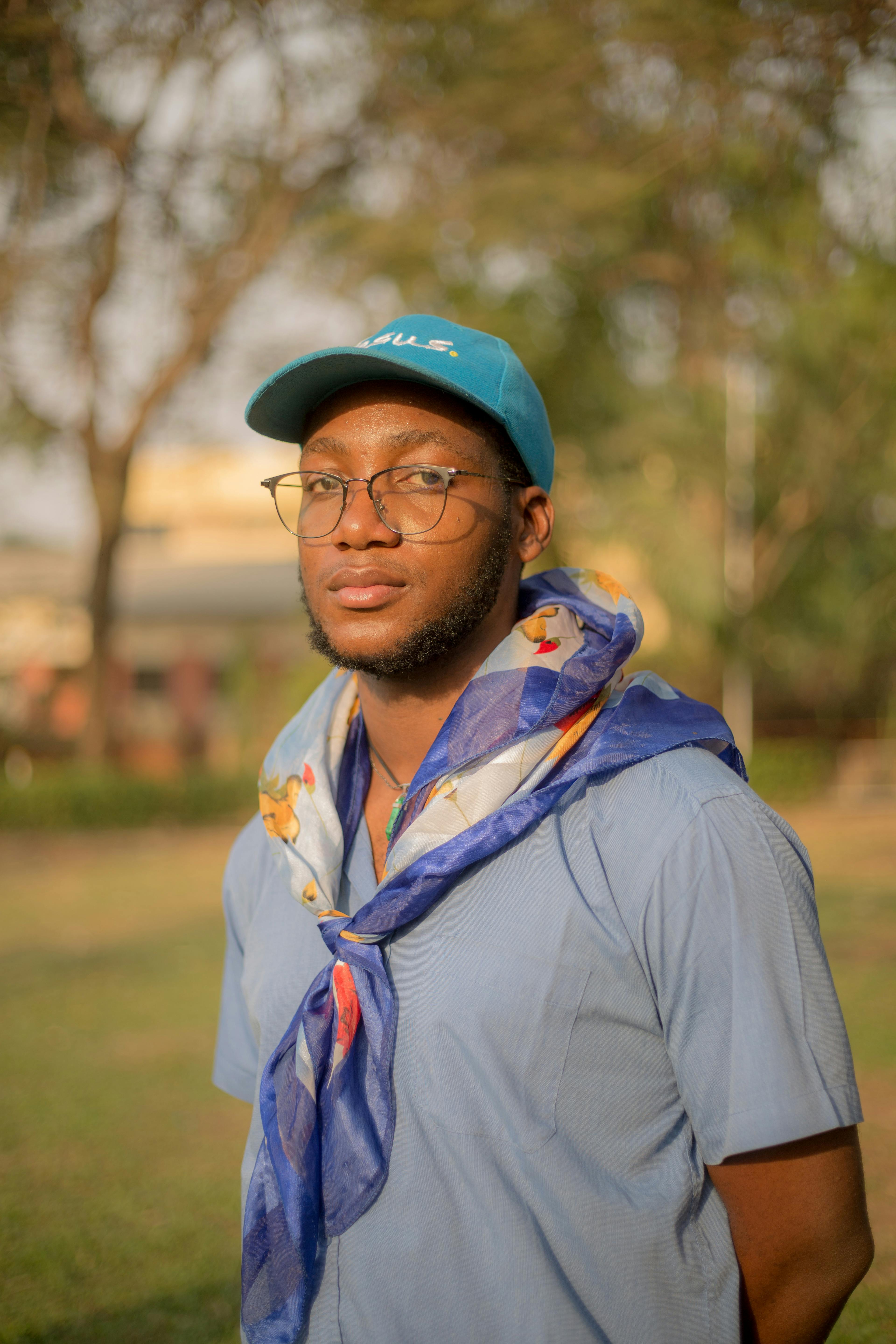 A serene portrait of a young African man in a park setting, capturing a calm atmosphere and natural light.