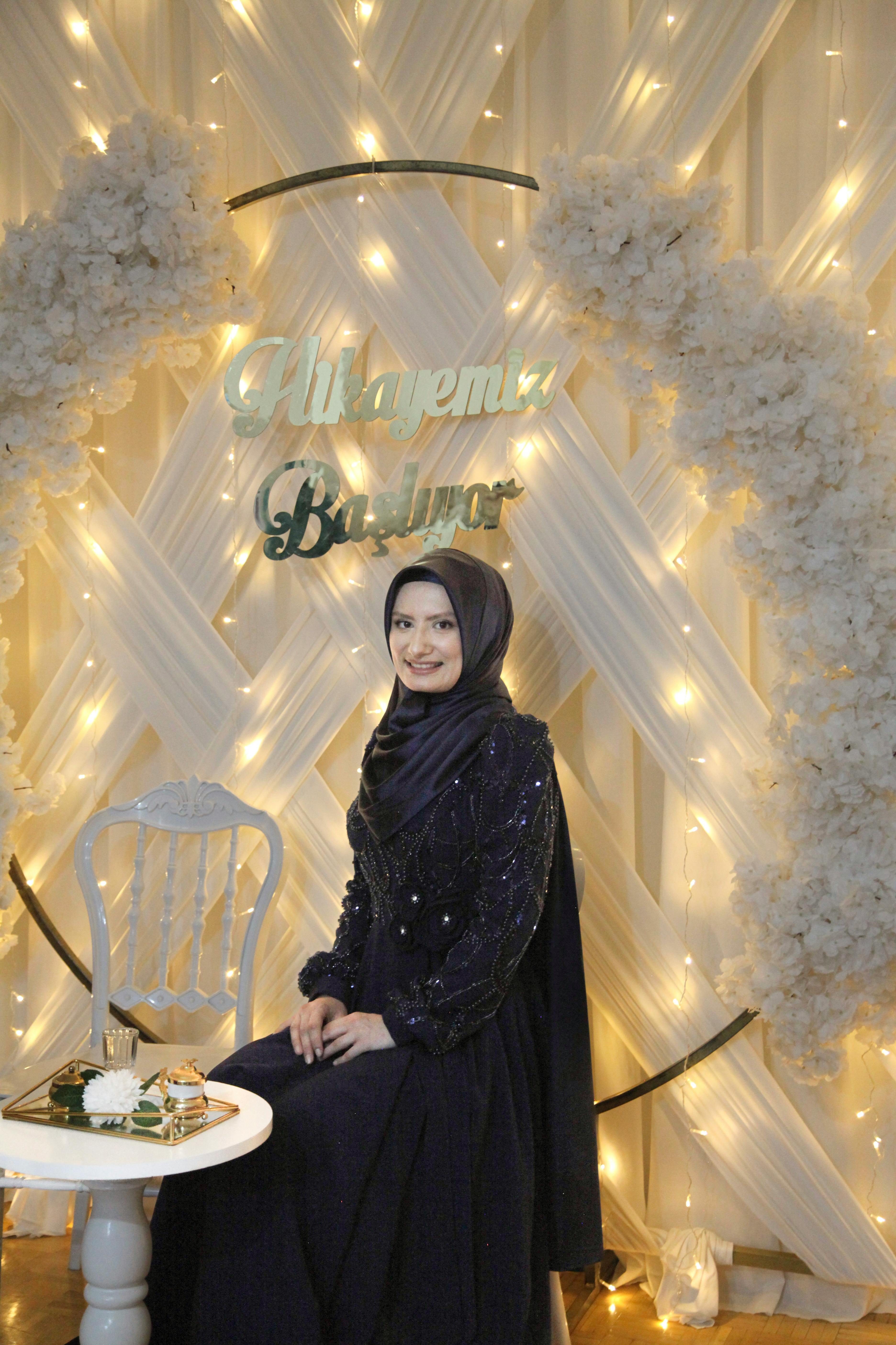 A beautifully decorated party backdrop with a woman in an elegant gown, showcasing a glamorous event setting.