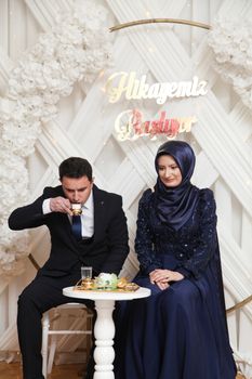 Couple celebrating engagement ceremony with tea and traditional attire. - Fotografer Sidoarjo