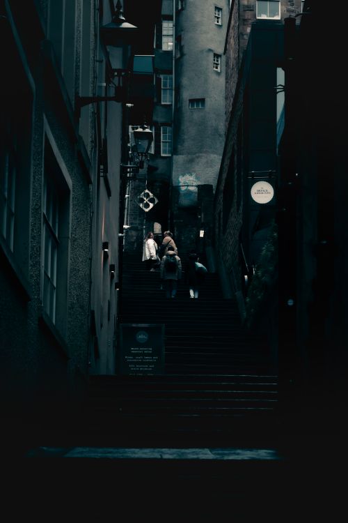 Free A dark, moody street scene in Edinburgh's historic alleys at night. Stock Photo