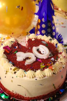A vibrant red velvet cake with decorative confetti celebrating a 30th birthday or anniversary.