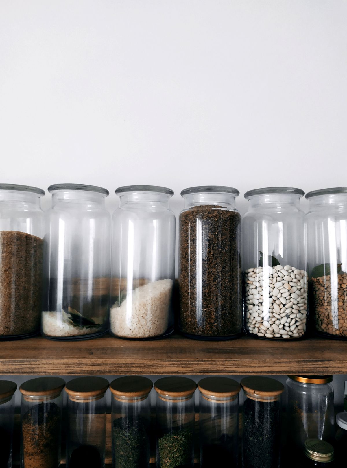Organized glass jars with grains and spices showing spice storage ideas