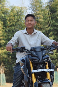 Young man riding a motorcycle with a nature backdrop. Adventure vibes.