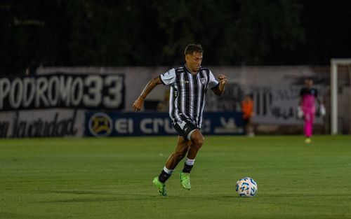 Free Soccer player in action dribbling the ball across the field during a night match. Stock Photo