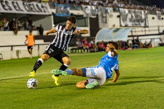 A dynamic moment of soccer players tackling under stadium lights during an exciting match.