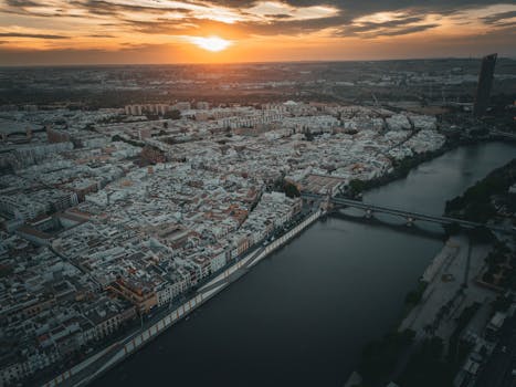 Stunning aerial view of Seville, Spain at sunset showcasing the city's architecture and river.