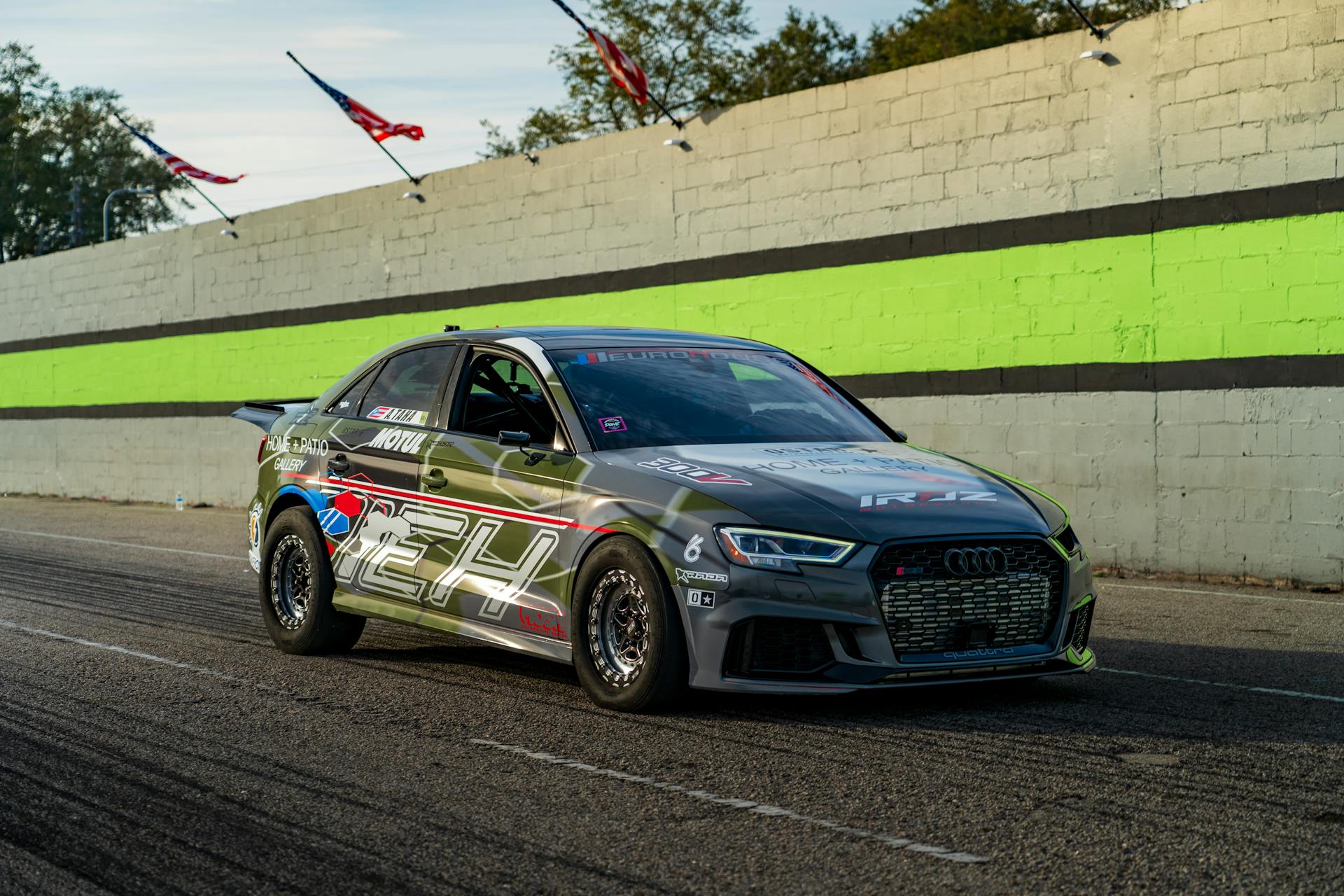 Race car speeding on track with vibrant backdrop. Dynamic and energetic scene.