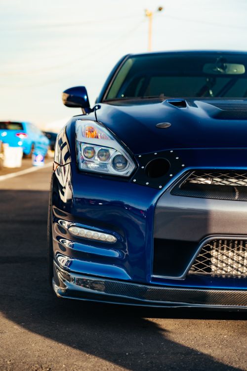 Free A vibrant blue sports car captured in detail on a sunny day at a race track. Stock Photo