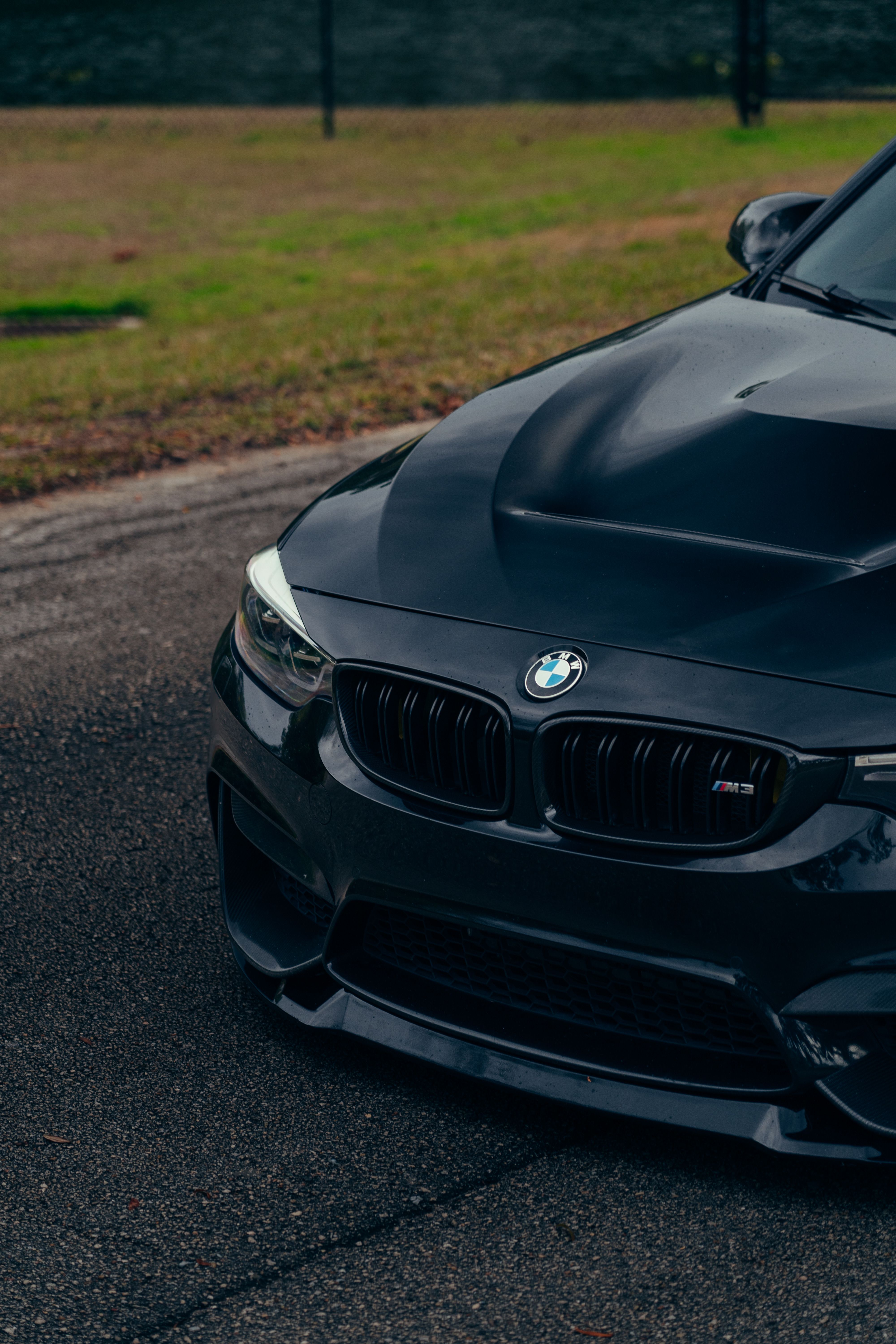 Close-up of a sleek black luxury car on a road capturing its elegant design and modern style.