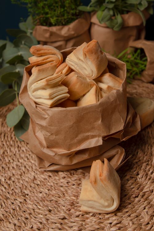 Free Freshly baked artisan bread in a rustic brown bag on a woven surface. Stock Photo
