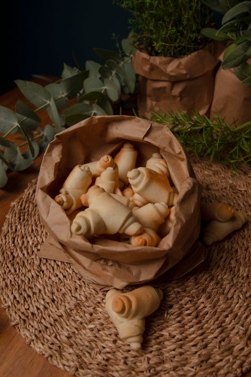 Free A cozy kitchen scene with a basket of croissants and herbs. Stock Photo