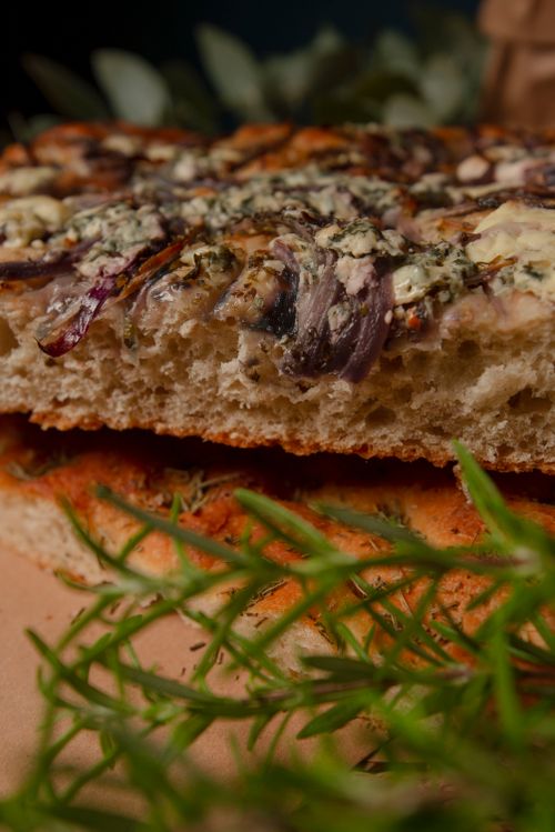Free Freshly baked focaccia bread with herbs and cheese topping. Stock Photo