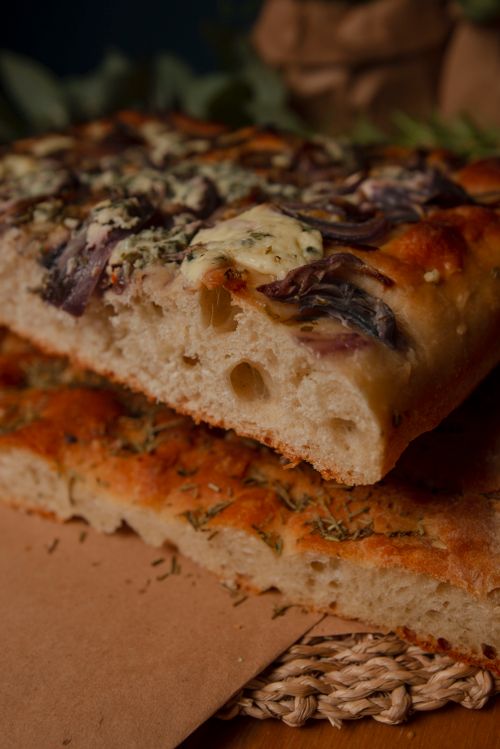 Free Delicious artisan focaccia bread with herbs and cheese, perfect for gourmet meals. Stock Photo