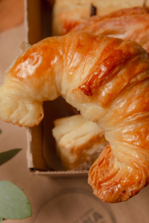 Free Close-up of a golden croissant in a box, showcasing flaky pastry layers. Stock Photo