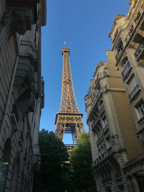 Free The Eiffel Tower seen through an architectural frame of Parisian buildings. Stock Photo