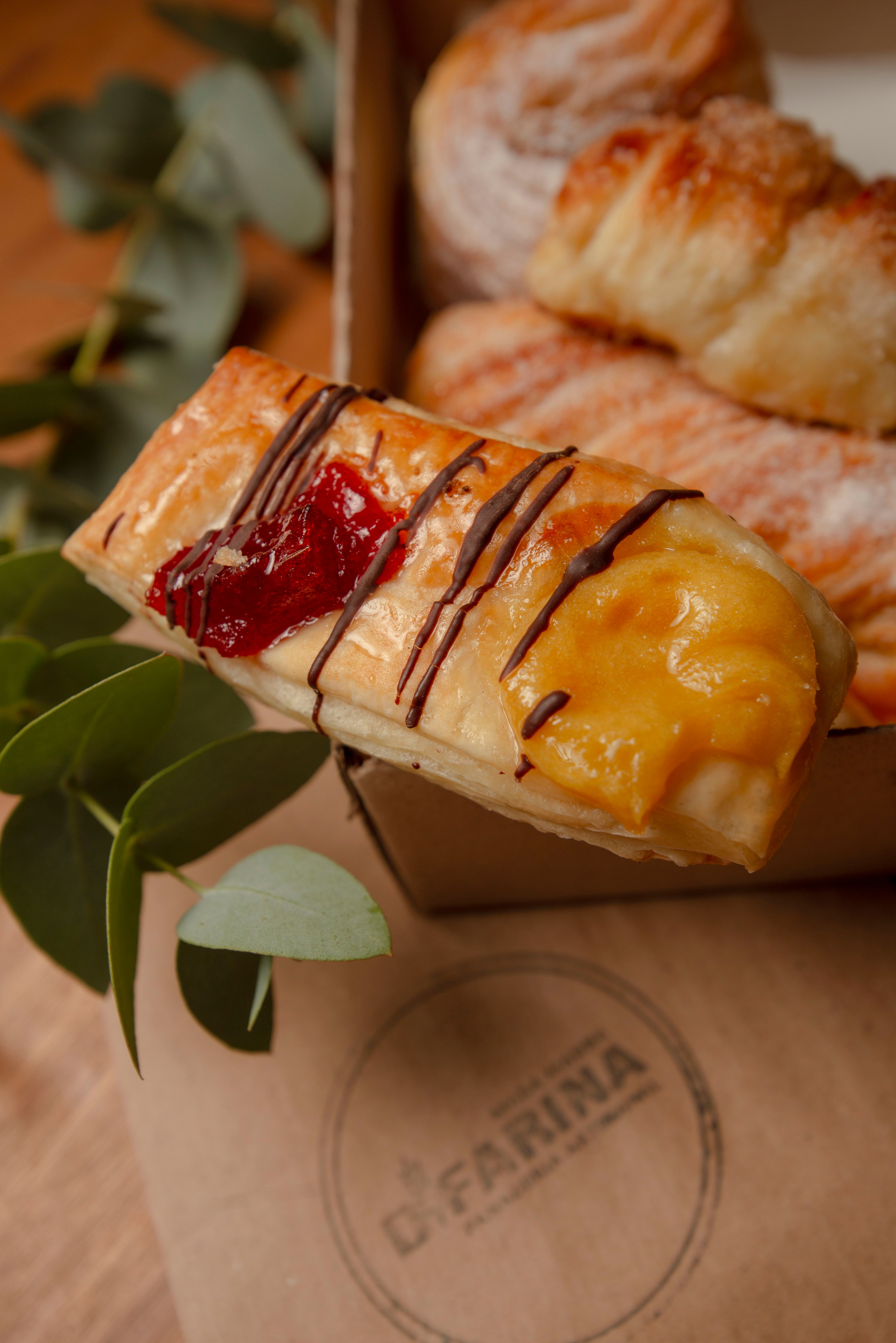 Close-up of assorted pastries with chocolate drizzle and fruit toppings, perfect for a tasty snack.