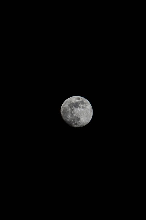 Free Detailed view of the moon's surface against a dark night sky, showcasing lunar craters. Stock Photo