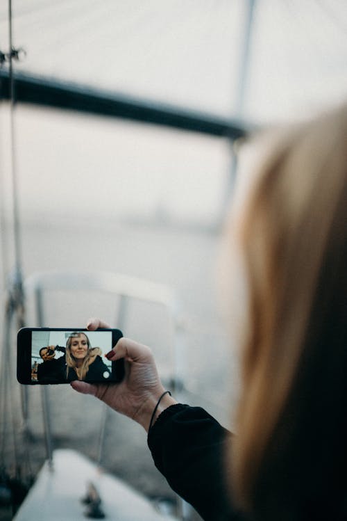 Woman Holding a Phone Taking Selfie