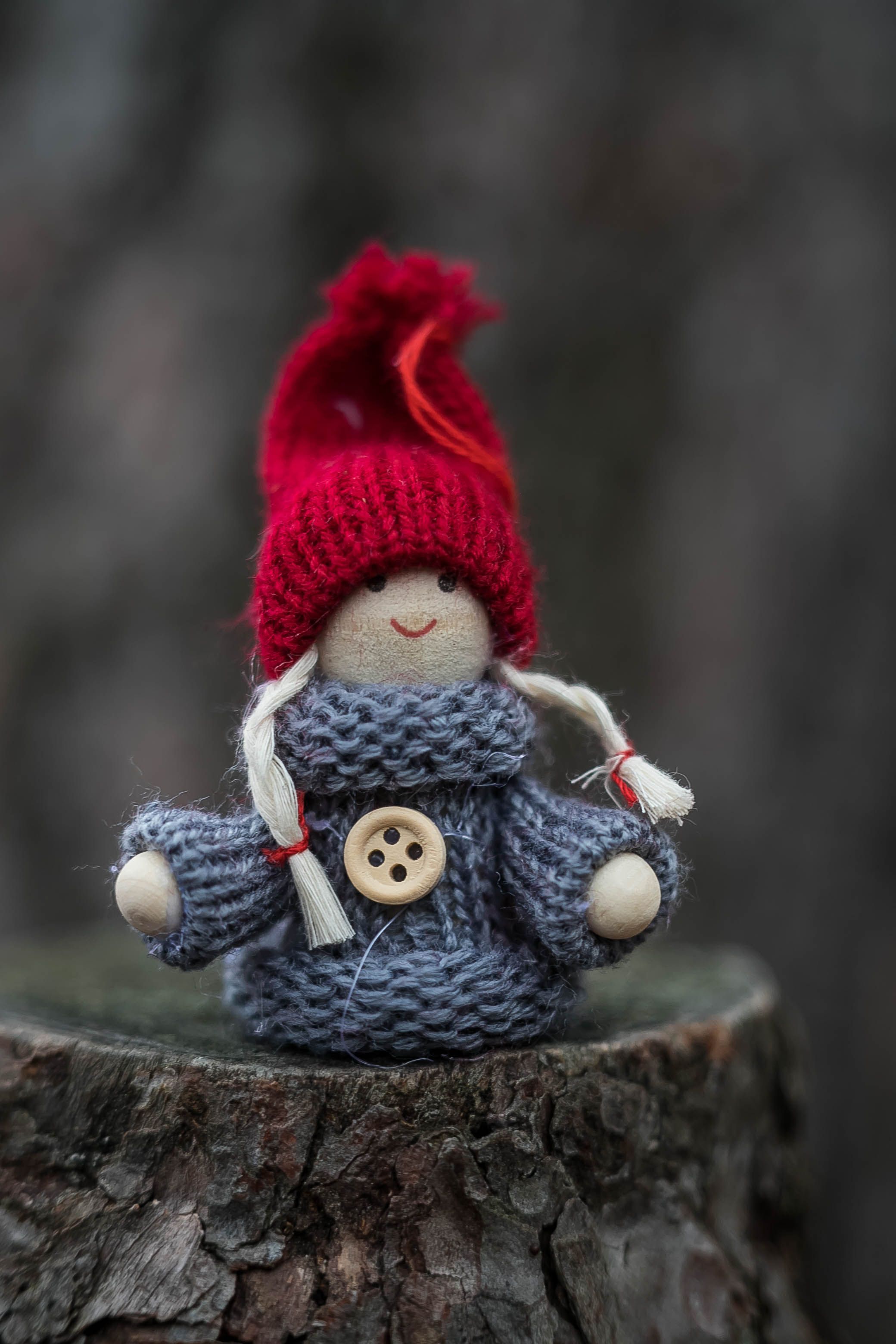Cute handcrafted doll with a knitted outfit and red hat, ideal for winter themes.