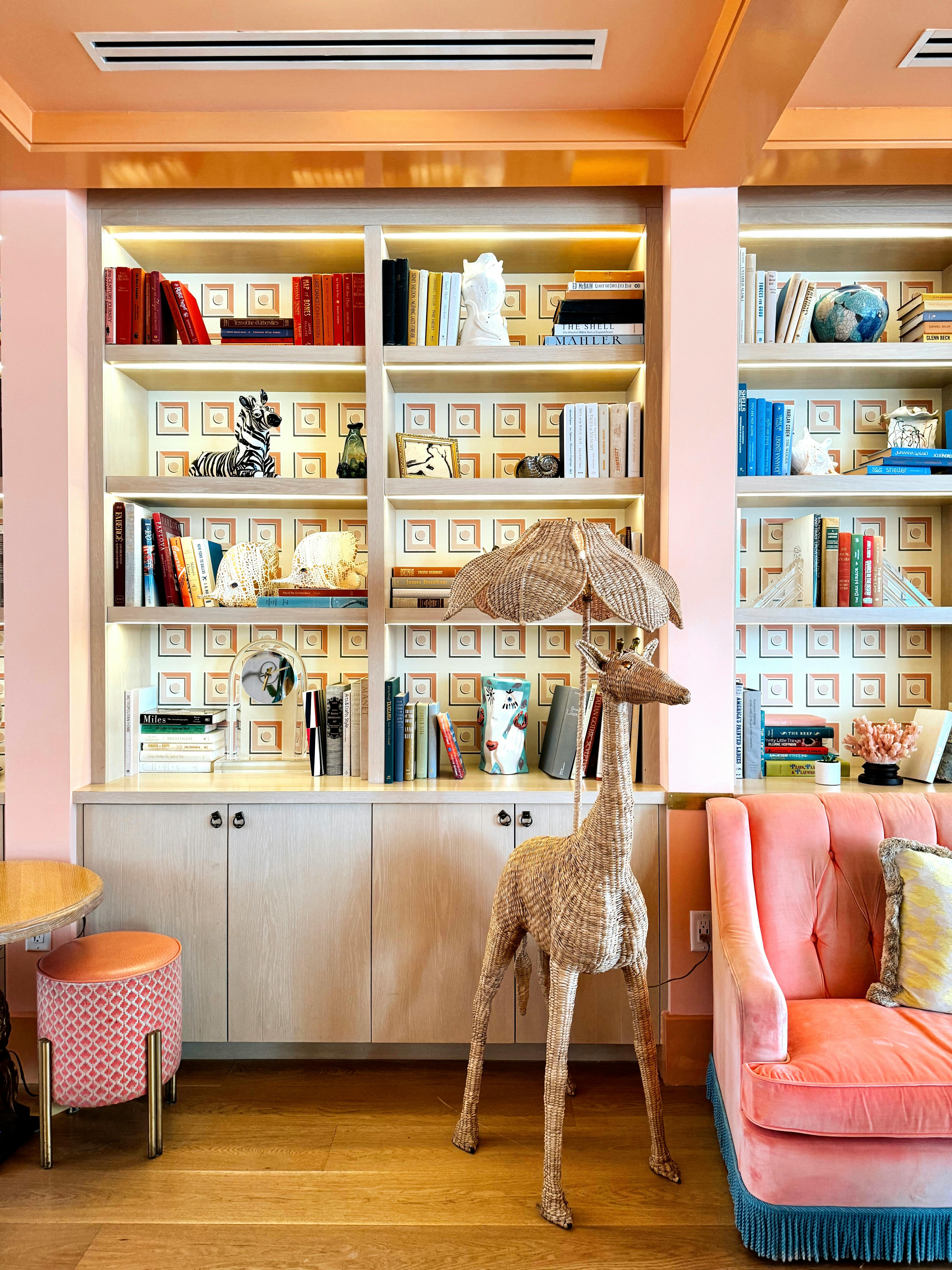 A living room where books, odd lamps and open shelving give the room a personality beyond the sofa.