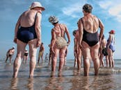 老年人聚集在海滩上，享受阳光明媚的一天