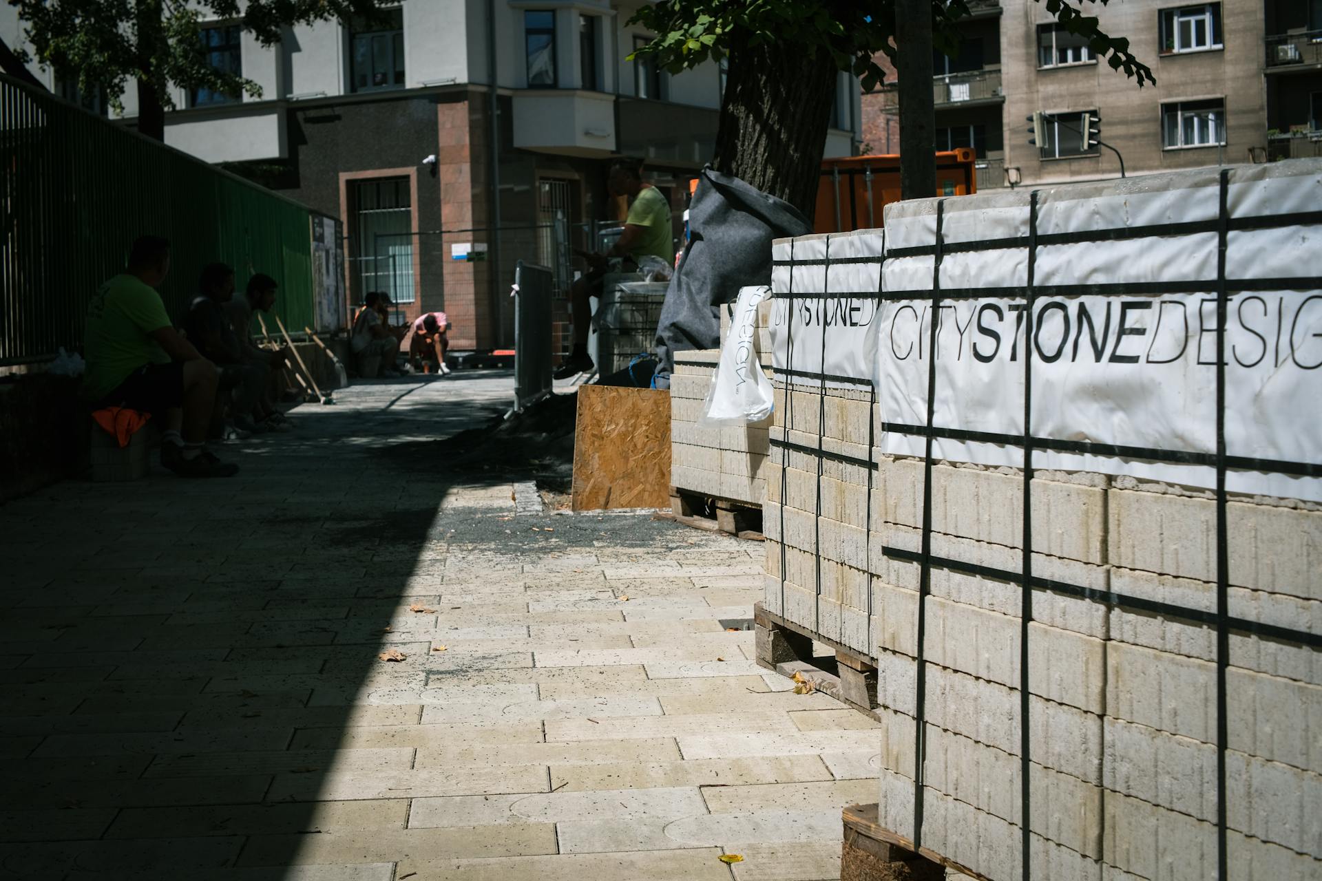 Street construction site in Bratislava with paving stones and workers.