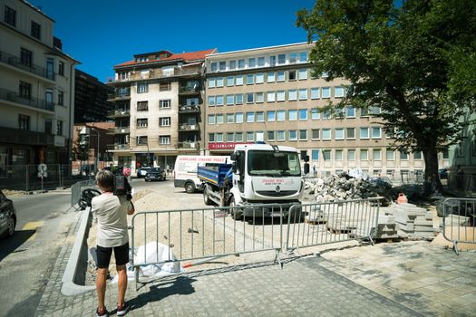 A scene of urban construction in Bratislava featuring a photographer capturing the progress.