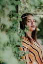 一名身穿条纹服装的女子自信地在户外绿叶中摆姿势