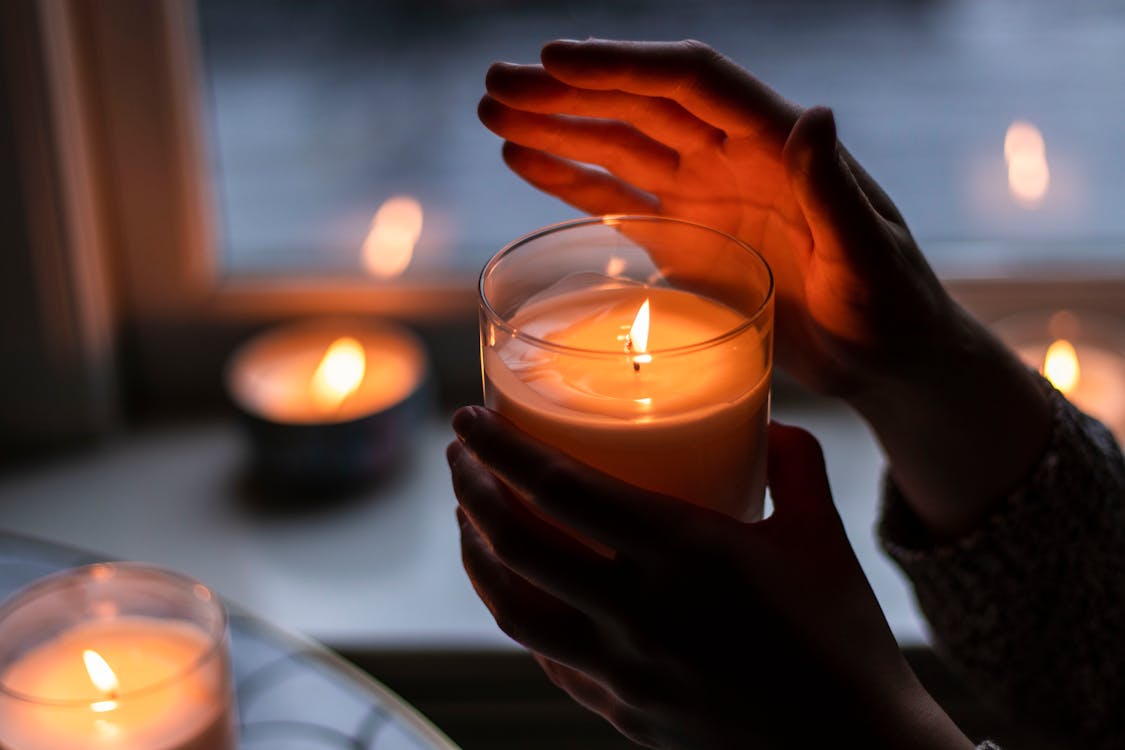 Photo of Person Holding Scented Candle