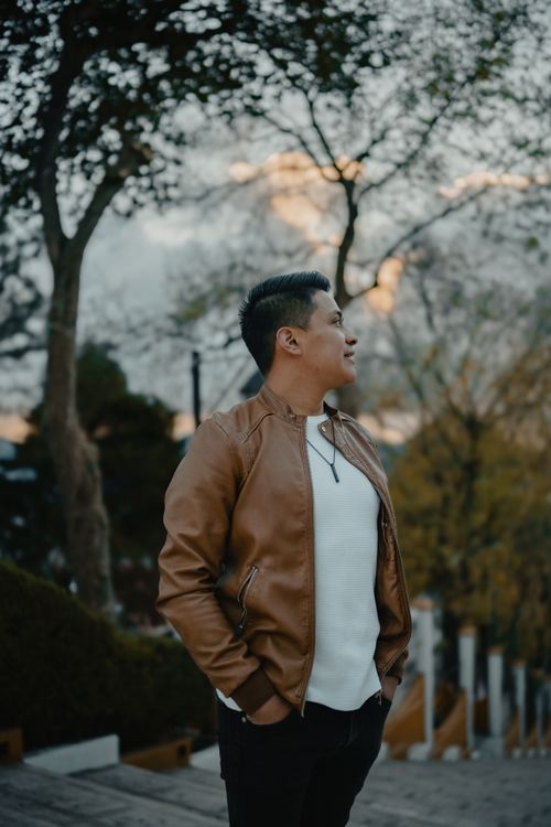 Free Young man in leather jacket enjoying a calm evening outdoors in San Cristóbal, Mexico. Stock Photo
