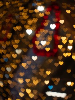 Golden heart-shaped bokeh lights create a romantic and warm atmosphere, perfect for Valentine's Day designs.