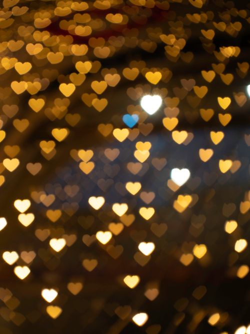 Free Warm and romantic heart-shaped bokeh lights creating an intimate ambiance. Stock Photo