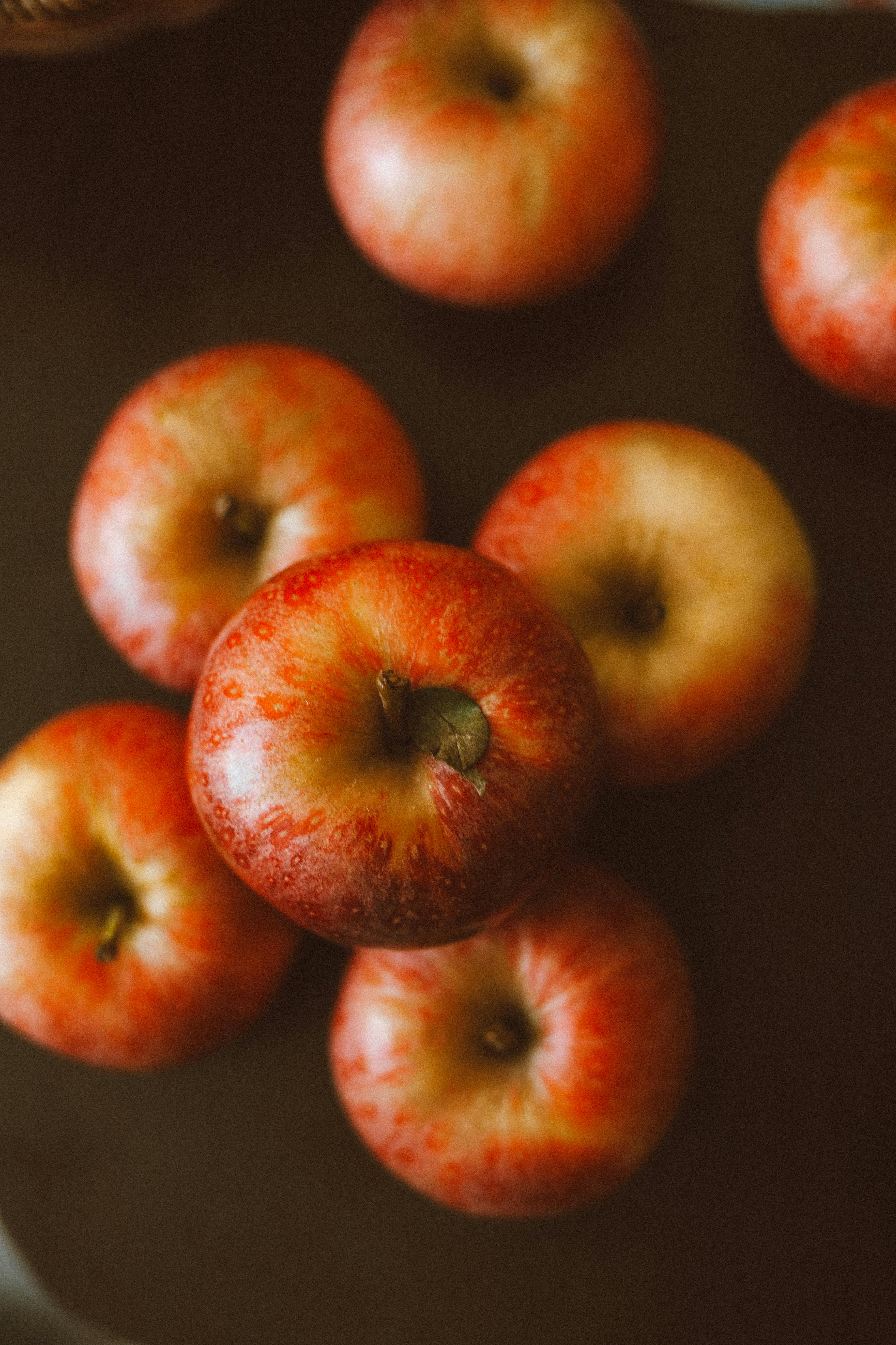 High-quality image of fresh red apples on a rustic wooden background.