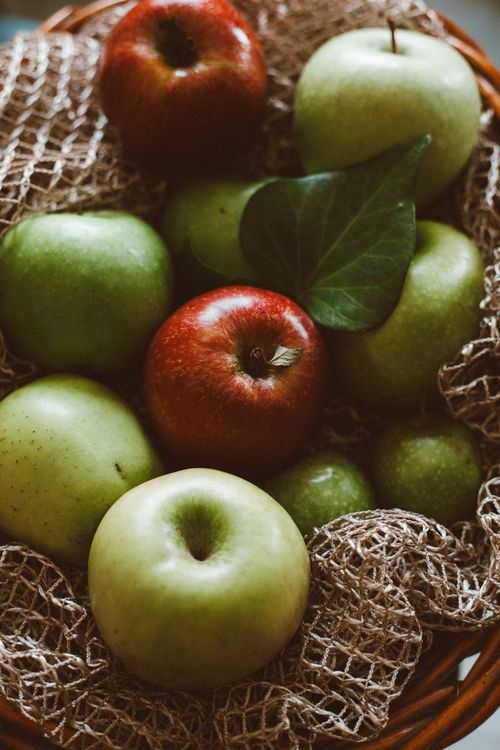 Free A selection of green and red apples in a basket covered with a cozy netting, captured indoors. Stock Photo
