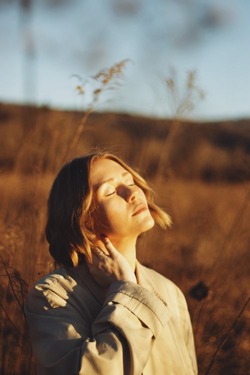 Free Peaceful portrait of a woman basking in golden autumn sunlight. Stock Photo