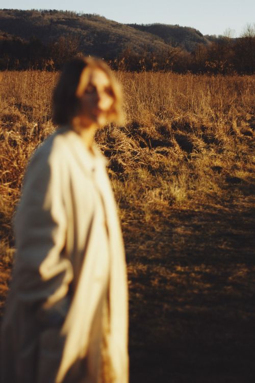 Free Blurred portrait in an autumn field during golden hour, capturing serene beauty and nature's warmth. Stock Photo
