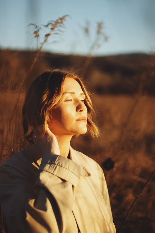 Free Woman in warm autumn light, capturing serene beauty outdoors. Stock Photo