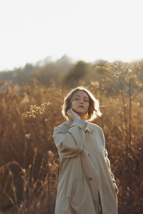 Free A serene portrait capturing a woman in a rustic autumn setting with soft light. Stock Photo