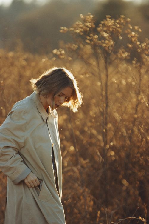 Free A serene portrait capturing a woman in an autumn field at golden hour. Stock Photo