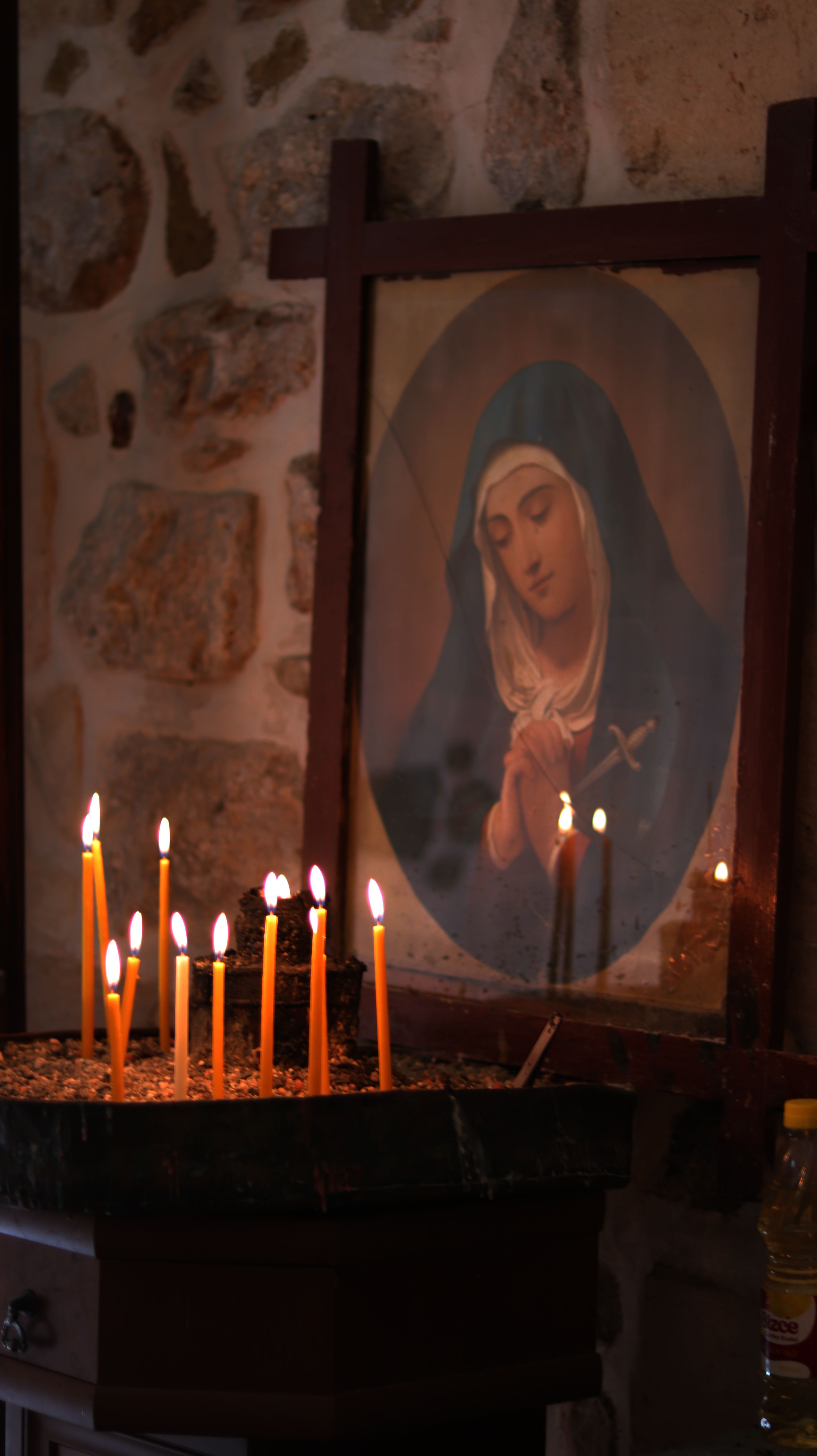 Candlelit scene of prayer with a portrait of Mary in a serene setting.