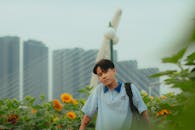 Young man amidst sunflowers with city skyline