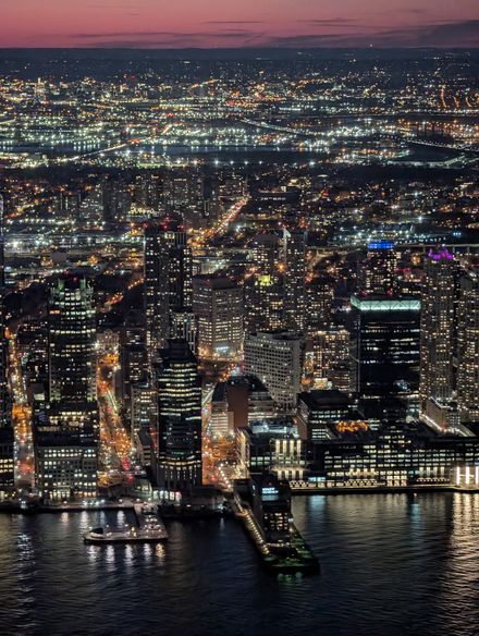 Aerial view of a city skyline lit up at twilight — photo by sn3k on Pexels