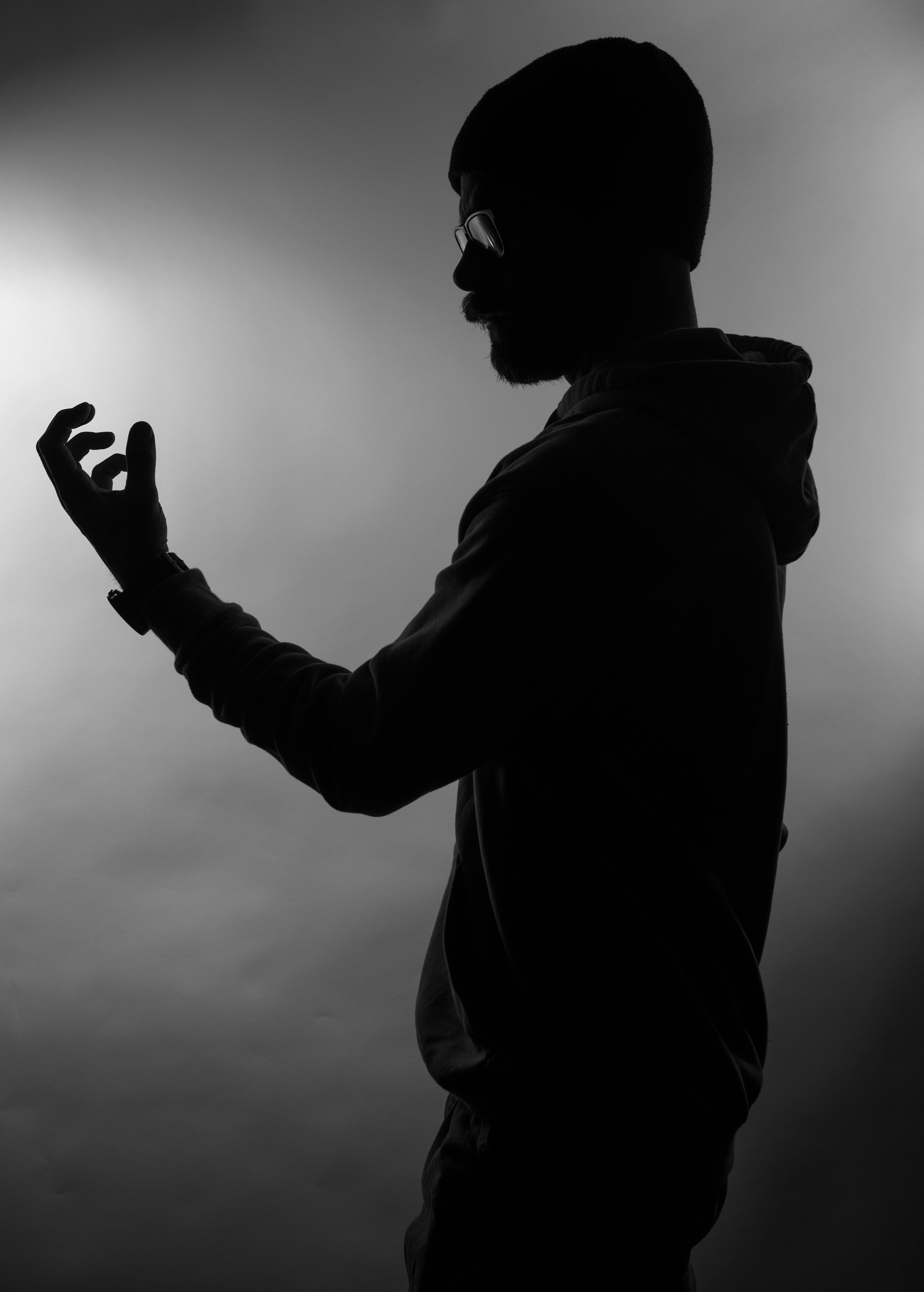 Gratis Siluet hitam putih seorang pria yang sedang merenung dengan gerakan tangan. Foto Stok