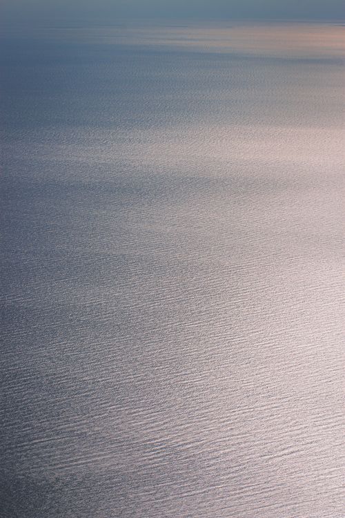 Free A calming aerial shot of ocean water reflecting soft twilight hues, showcasing peaceful ripples. Stock Photo