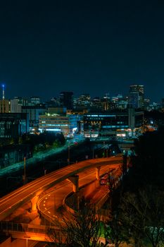A stunning night cityscape featuring a brightly lit city skyline and illuminated roads with a smooth curve.
