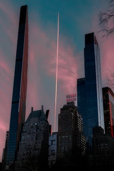 Dramatic dusk view of New York's skyline featuring Essex House and skyscrapers.