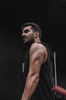 Close-up of a muscular man in a gym, showcasing strength and fitness determination.