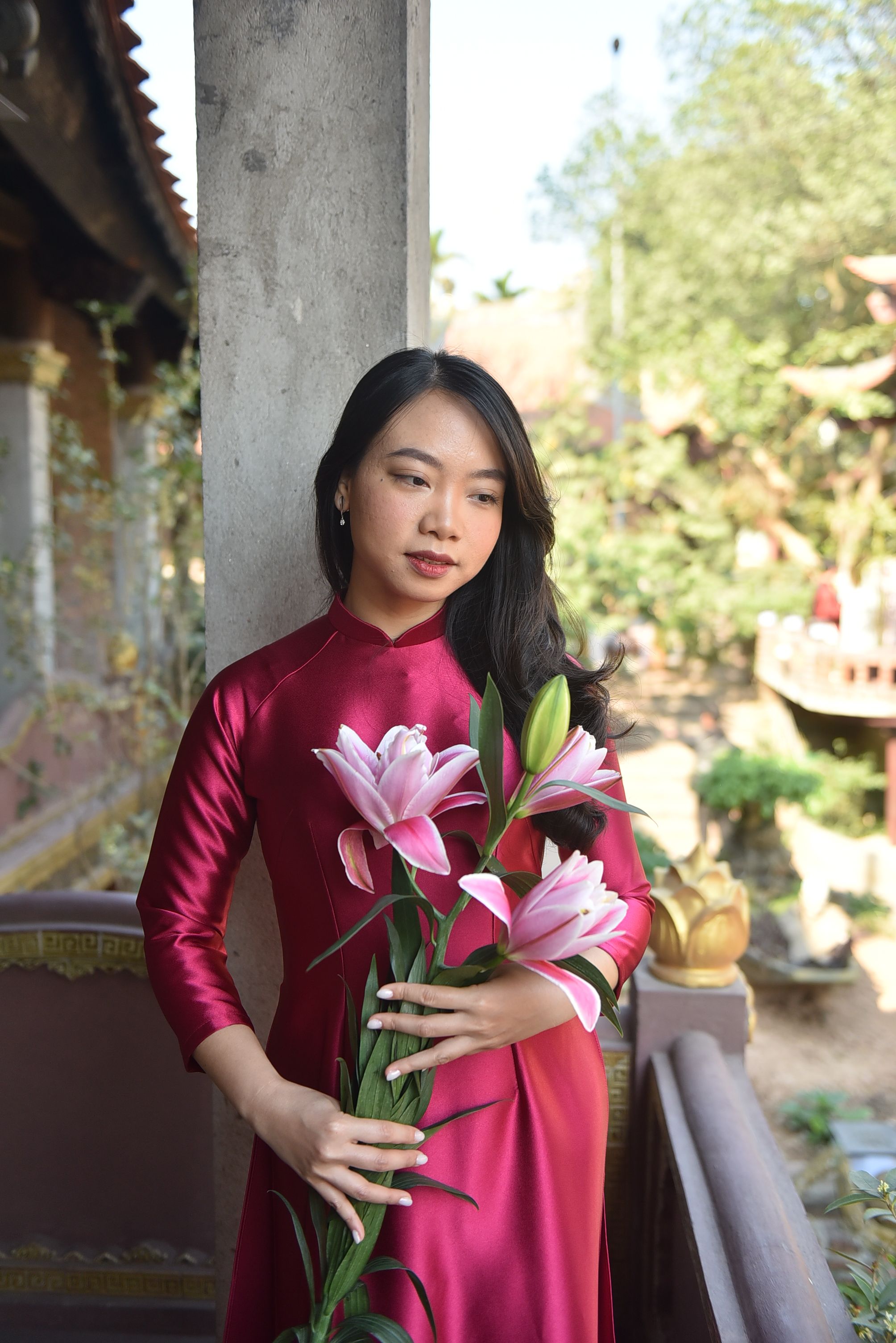 Young woman in traditional dress holding lilies · Free Stock Photo